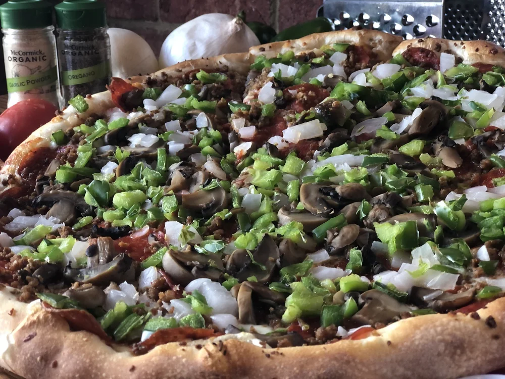 A loaded Mozzi's specialty pizza fresh out of the oven
