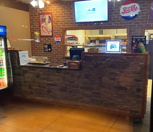 Mozzi's Pizza Greenfield N State location interior — stone counter and brick wall